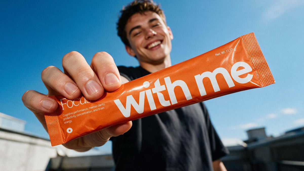 A smiling man outdoors holding out an orange Focus stick pack
