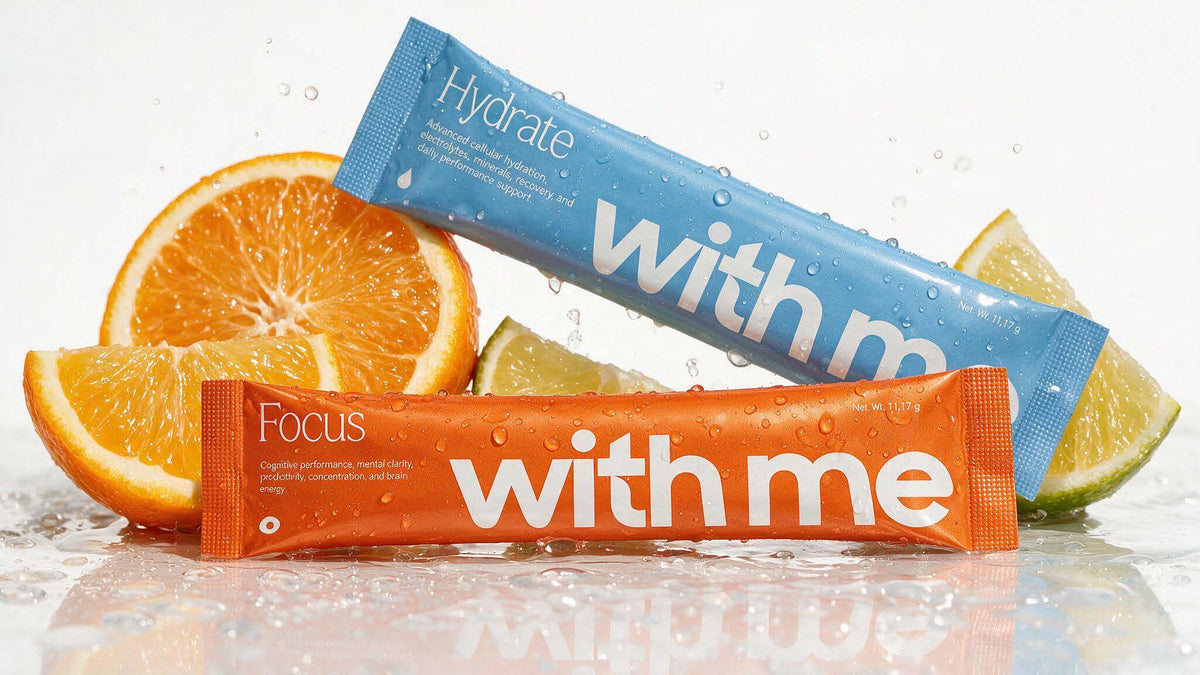 Blue Hydrate and orange Focus stick packs among fresh orange and lime slices
